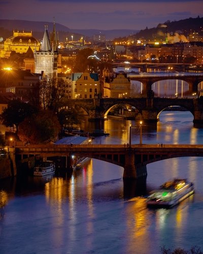 landscape with Vltava river, Karlov most and boat at night in autumn in Prague, Czech Republic. Prague Castle Tickets